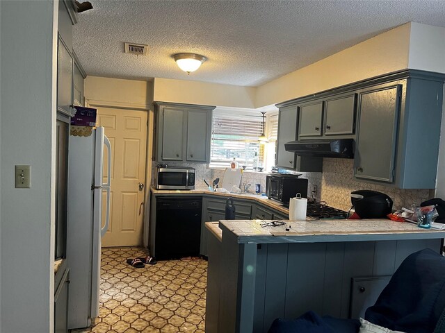 10005 Cypress N Houston Rd, Houston, TX 77070 - kitchen with a peninsula, black appliances, under cabinet range hood, tasteful backsplash, and a textured ceiling
