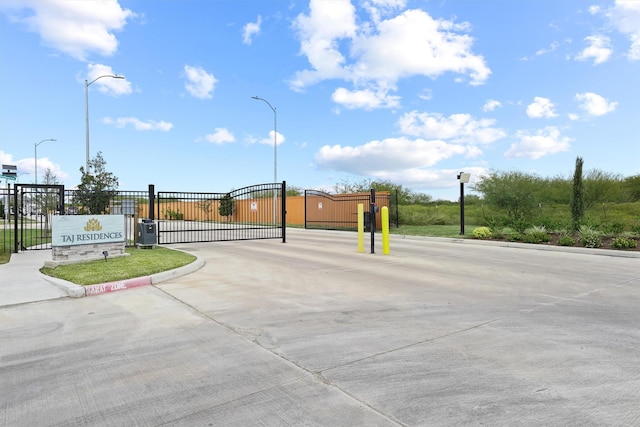10406 Grove Row Ave, Richmond, TX 77407 - view of concrete road with curbs, a gate, street lighting, and a gated entry