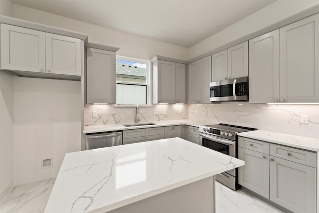 10406 Grove Row Ave, Richmond, TX 77407 - kitchen with appliances with stainless steel finishes, light marble finish flooring, light stone countertops, gray cabinetry, and decorative backsplash