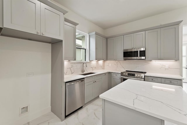 10406 Grove Row Ave, Richmond, TX 77407 - kitchen featuring stainless steel appliances, light marble finish flooring, light stone countertops, gray cabinetry, and backsplash