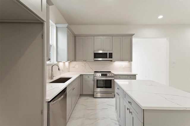 10406 Grove Row Ave, Richmond, TX 77407 - kitchen with appliances with stainless steel finishes, gray cabinetry, light marble finish flooring, tasteful backsplash, and light stone countertops
