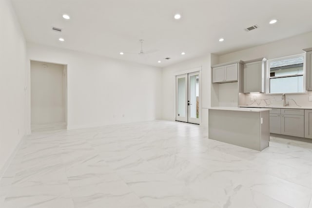 10406 Grove Row Ave, Richmond, TX 77407 - kitchen featuring light marble finish flooring, gray cabinetry, recessed lighting, a kitchen island, and ceiling fan