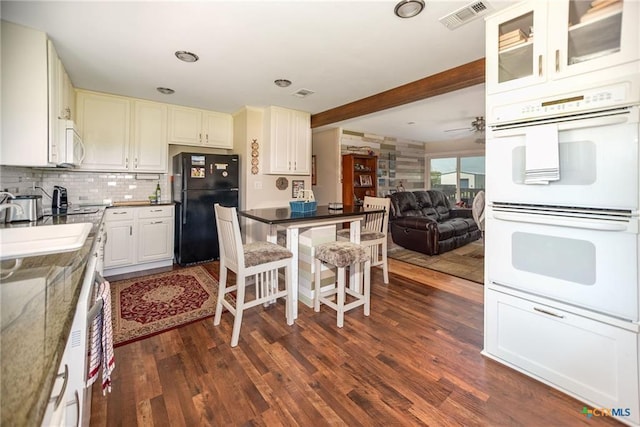 40 Sailfish Lndg, Port Lavaca, TX 77979 - kitchen with white appliances, dark wood-style flooring, tasteful backsplash, beamed ceiling, and open floor plan