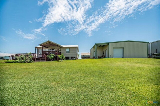 40 Sailfish Lndg, Port Lavaca, TX 77979 - view of grassy yard with a detached garage, an outdoor structure, a wooden deck, and a pole building