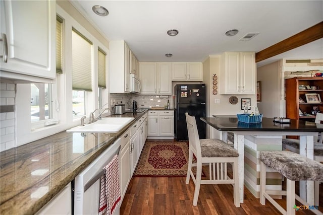 40 Sailfish Lndg, Port Lavaca, TX 77979 - kitchen featuring freestanding refrigerator, a kitchen breakfast bar, wine cooler, backsplash, and white cabinets