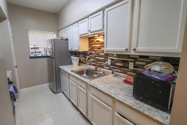 7264 Regency Square Ct, Houston, TX 77036 - kitchen with white dishwasher, tasteful backsplash, light tile patterned flooring, white cabinets, and light stone counters