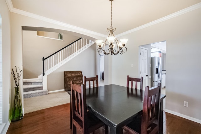 3817 Dunlavy Dr, Pearland, TX 77581 - dining space with a chandelier, stairs, crown molding, dark wood-style floors, and arched walkways