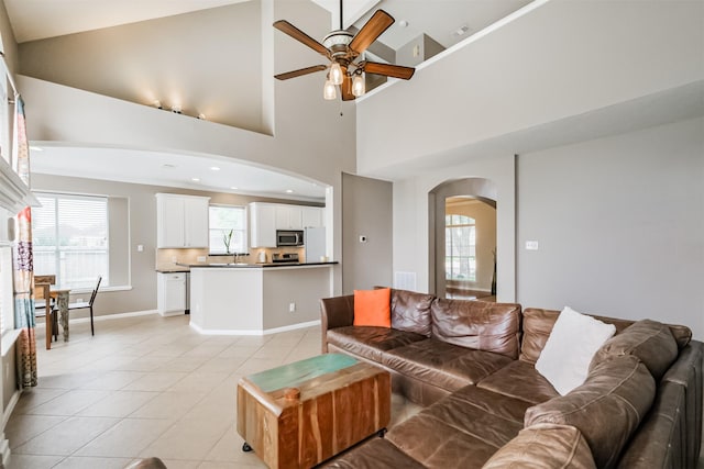 3817 Dunlavy Dr, Pearland, TX 77581 - living area featuring arched walkways, ceiling fan, light tile patterned floors, and a high ceiling