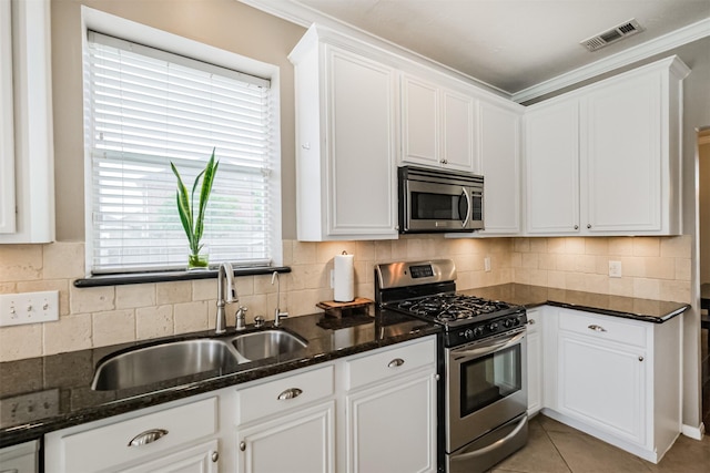 3817 Dunlavy Dr, Pearland, TX 77581 - kitchen featuring appliances with stainless steel finishes, white cabinetry, dark stone counters, tasteful backsplash, and crown molding