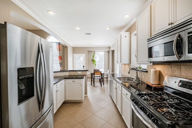 3817 Dunlavy Dr, Pearland, TX 77581 - kitchen featuring appliances with stainless steel finishes, dark countertops, backsplash, a peninsula, and crown molding