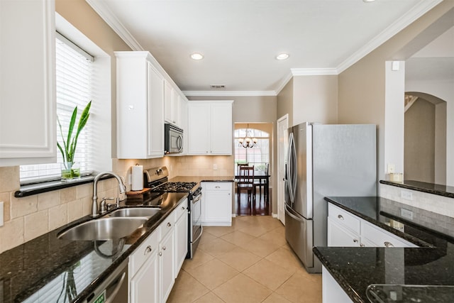 3817 Dunlavy Dr, Pearland, TX 77581 - kitchen with stainless steel appliances, white cabinets, decorative backsplash, a chandelier, and ornamental molding