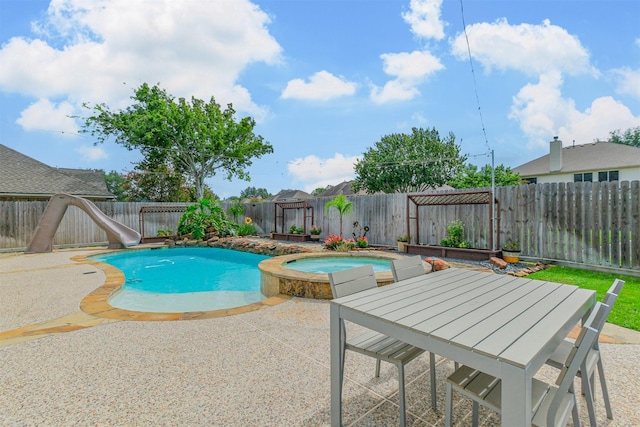 3817 Dunlavy Dr, Pearland, TX 77581 - view of pool with a water slide, a patio, a fenced backyard, and a pool with connected hot tub