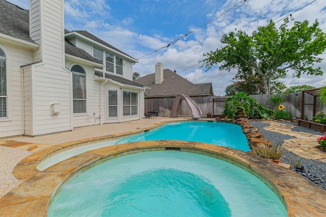 3817 Dunlavy Dr, Pearland, TX 77581 - view of pool featuring a water slide, a fenced backyard, a patio area, and a pool with connected hot tub