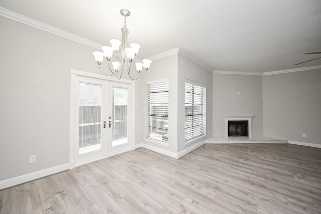 9707 Richmond Ave Unit 3, Houston, TX 77042 - unfurnished living room featuring french doors, crown molding, a chandelier, light wood-style floors, and a tile fireplace