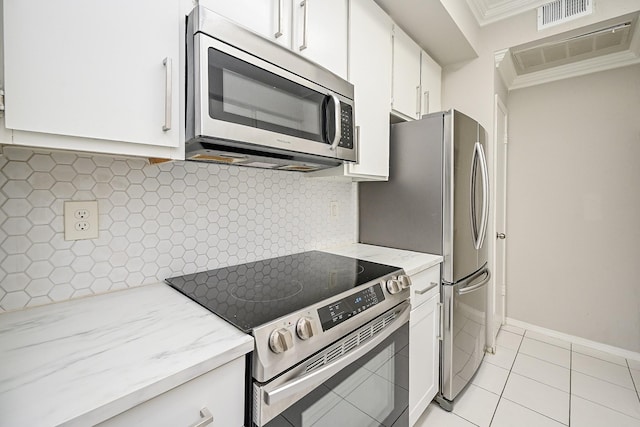 9707 Richmond Ave Unit 3, Houston, TX 77042 - kitchen featuring stainless steel appliances, white cabinetry, crown molding, light stone countertops, and light tile patterned flooring