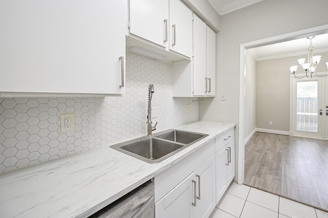 9707 Richmond Ave Unit 3, Houston, TX 77042 - kitchen with crown molding, white cabinetry, a chandelier, backsplash, and light stone countertops