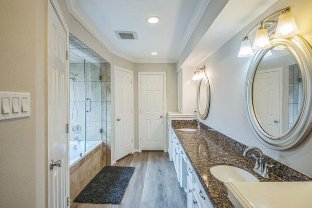 18318 Widcombe Dr, Houston, TX 77084 - bathroom with tiled shower / bath combo, double vanity, wood finished floors, ornamental molding, and recessed lighting