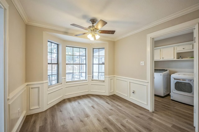 18318 Widcombe Dr, Houston, TX 77084 - unfurnished dining area featuring a ceiling fan, light wood-style floors, washing machine and clothes dryer, crown molding, and wainscoting