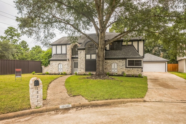 18318 Widcombe Dr, Houston, TX 77084 - tudor-style house featuring a shingled roof, a detached garage, and stone siding