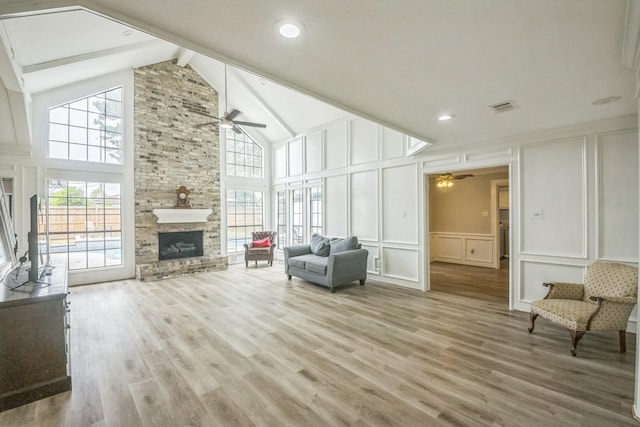 18318 Widcombe Dr, Houston, TX 77084 - living area with ceiling fan, a decorative wall, beam ceiling, a stone fireplace, and high vaulted ceiling