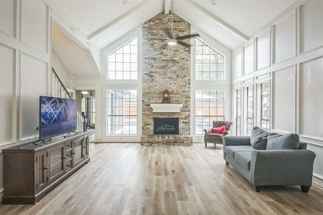 18318 Widcombe Dr, Houston, TX 77084 - living room with high vaulted ceiling, a ceiling fan, light wood-style floors, a large fireplace, and plenty of natural light