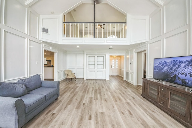 18318 Widcombe Dr, Houston, TX 77084 - living area with a decorative wall, a towering ceiling, light wood-style floors, and a chandelier