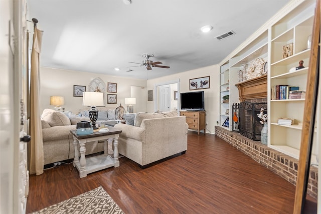 907 E Houston Ave, Crockett, TX 75835 - living area featuring a brick fireplace, ceiling fan, dark wood-type flooring, built in shelves, and recessed lighting
