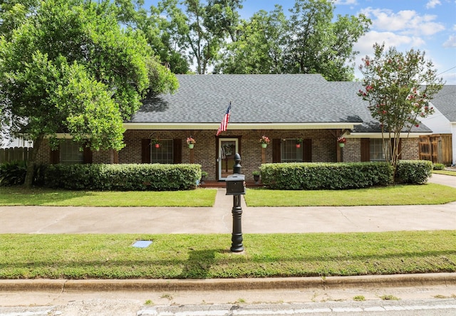 907 E Houston Ave, Crockett, TX 75835 - view of front of home featuring brick siding, a shingled roof, and covered porch