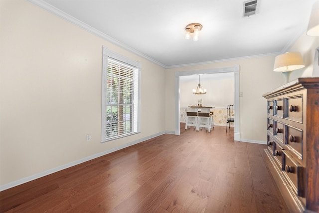 907 E Houston Ave, Crockett, TX 75835 - unfurnished room with wood finished floors, a chandelier, and crown molding