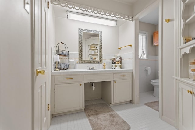 907 E Houston Ave, Crockett, TX 75835 - bathroom featuring vanity, tile walls, a wainscoted wall, and tile patterned flooring