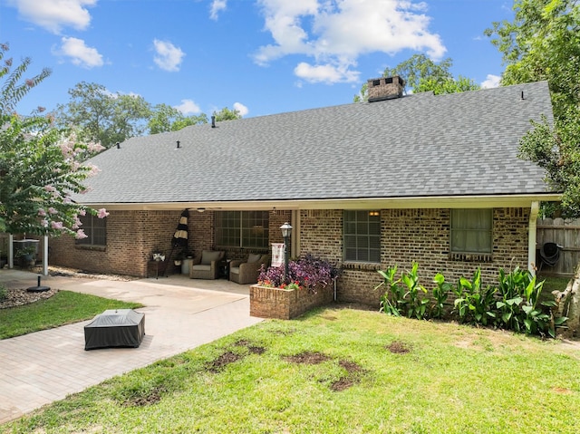 907 E Houston Ave, Crockett, TX 75835 - rear view of house with a patio, a shingled roof, a chimney, brick siding, and outdoor lounge area