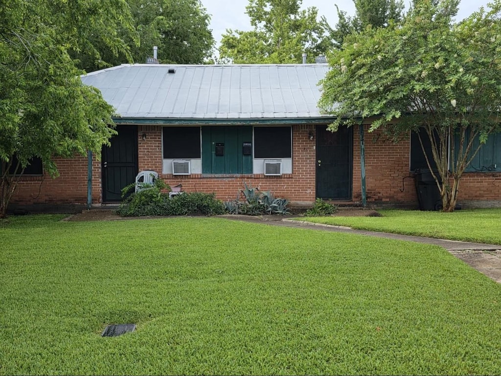 4117 Dawson Ln, Houston, TX 77051 - ranch-style home featuring a front yard, brick siding, cooling unit, and a metal roof