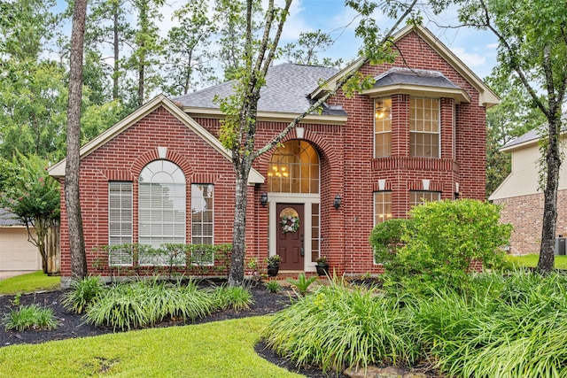 107 N Sunny Slope Cir, The Woodlands, TX 77381 - view of front of property with brick siding, a shingled roof, and a garage