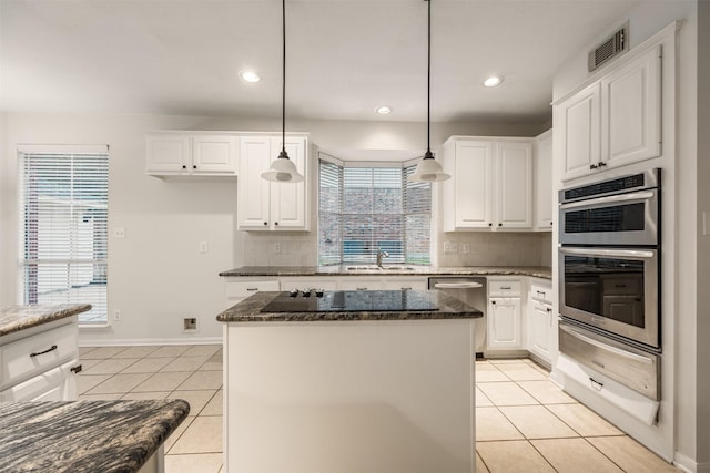 107 N Sunny Slope Cir, The Woodlands, TX 77381 - kitchen featuring appliances with stainless steel finishes, a warming drawer, light tile patterned floors, backsplash, and recessed lighting