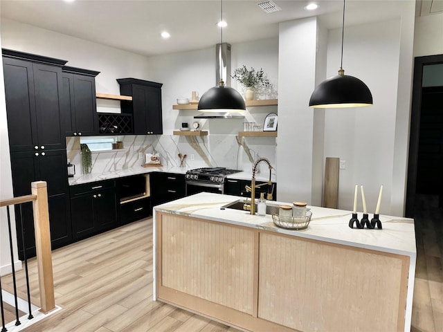 308 E 36th St, Houston, TX 77018 - kitchen with open shelves, dark cabinetry, stainless steel gas range oven, light wood-type flooring, and recessed lighting