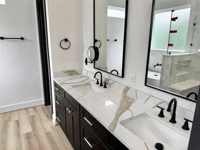 308 E 36th St, Houston, TX 77018 - bathroom featuring double vanity, tiled shower, and wood finished floors