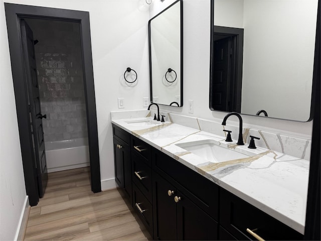 308 E 36th St, Houston, TX 77018 - bathroom with double vanity, wood finished floors, and washtub / shower combination