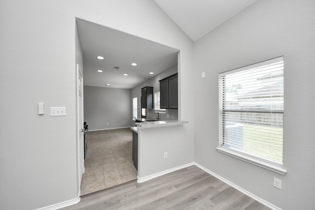 10342 Whisper Bluff Dr, Humble, TX 77396 - kitchen with healthy amount of natural light, light countertops, light wood-type flooring, recessed lighting, and dark cabinetry