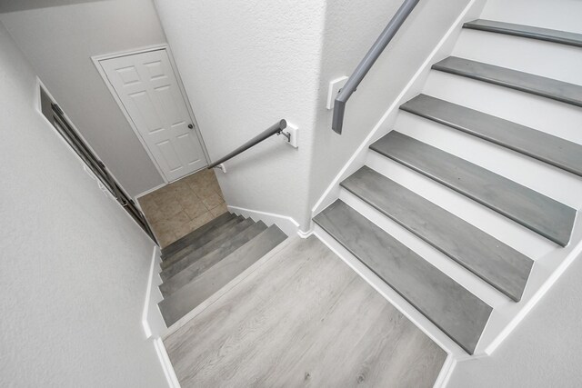 10342 Whisper Bluff Dr, Humble, TX 77396 - staircase featuring wood finished floors and baseboards