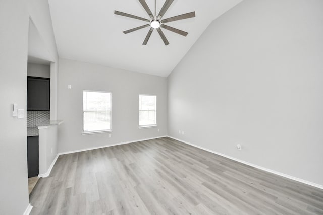 10342 Whisper Bluff Dr, Humble, TX 77396 - unfurnished living room featuring a ceiling fan, light wood-style flooring, high vaulted ceiling, and a fireplace