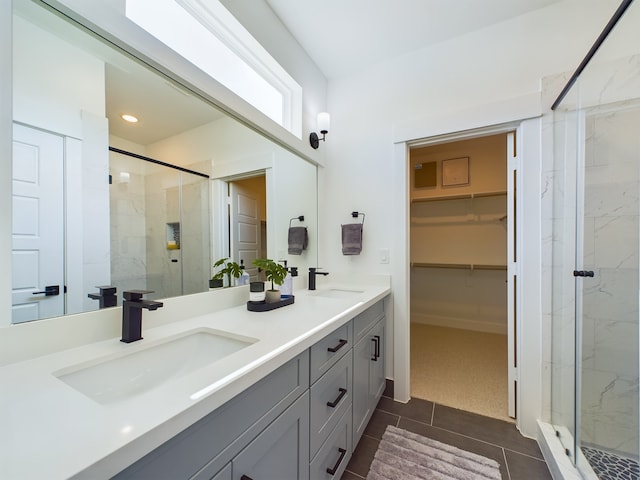 8317 Springwood Canyon Ln, Houston, TX 77055 - bathroom featuring a marble finish shower, double vanity, a walk in closet, tile patterned floors, and recessed lighting
