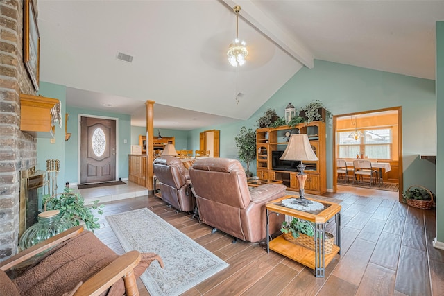 15435 Rio Plaza Dr, Houston, TX 77083 - living room featuring beamed ceiling, decorative columns, a fireplace, wood finished floors, and high vaulted ceiling