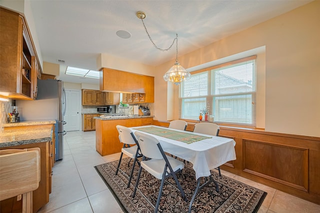 15435 Rio Plaza Dr, Houston, TX 77083 - dining area with a chandelier, a wainscoted wall, and light tile patterned flooring