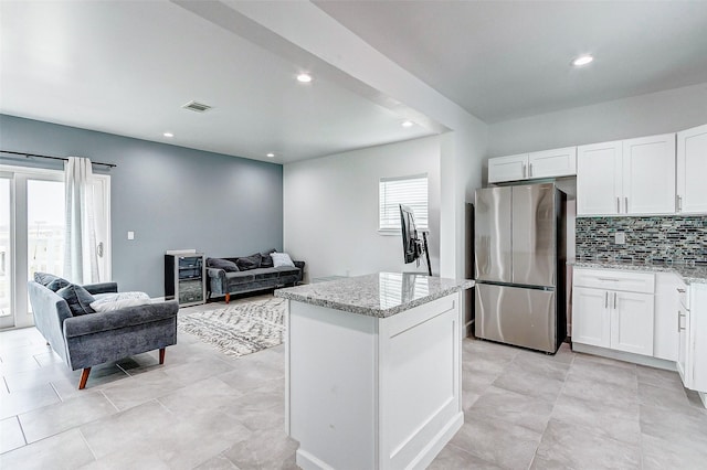 4018 6th St, Galveston, TX 77554 - kitchen featuring freestanding refrigerator, light stone counters, tasteful backsplash, white cabinets, and recessed lighting