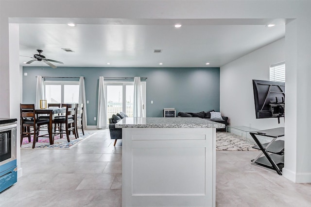 4018 6th St, Galveston, TX 77554 - kitchen featuring healthy amount of natural light, open floor plan, light stone countertops, recessed lighting, and white cabinetry
