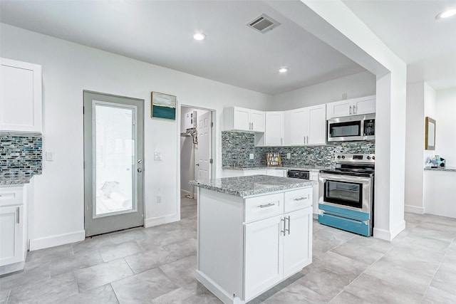 4018 6th St, Galveston, TX 77554 - kitchen with stainless steel appliances, decorative backsplash, light stone countertops, white cabinetry, and recessed lighting