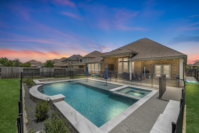 15519 Ponderosa Bend Dr, Cypress, TX 77429 - pool at dusk featuring a fenced backyard, a patio, a pool with connected hot tub, and area for grilling