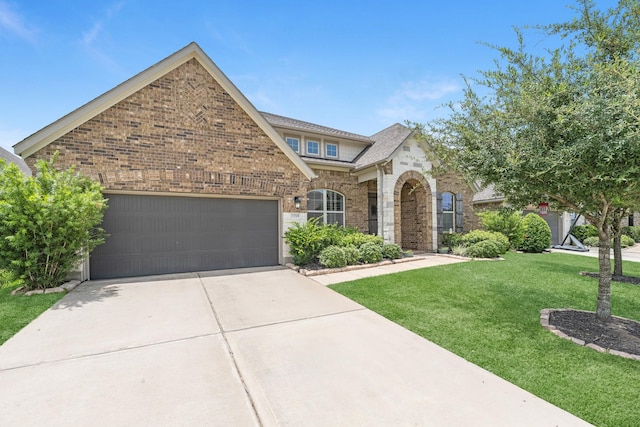 15519 Ponderosa Bend Dr, Cypress, TX 77429 - view of front of home with driveway, a front yard, an attached garage, brick siding, and stone siding