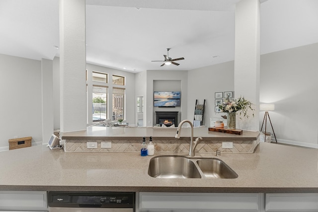 15519 Ponderosa Bend Dr, Cypress, TX 77429 - kitchen featuring stainless steel dishwasher, open floor plan, a glass covered fireplace, a ceiling fan, and white cabinets