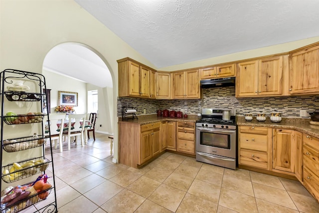 19757 Dorris Dr, Magnolia, TX 77355 - kitchen with stainless steel range with gas stovetop, vaulted ceiling, range hood, decorative backsplash, and light tile patterned flooring
